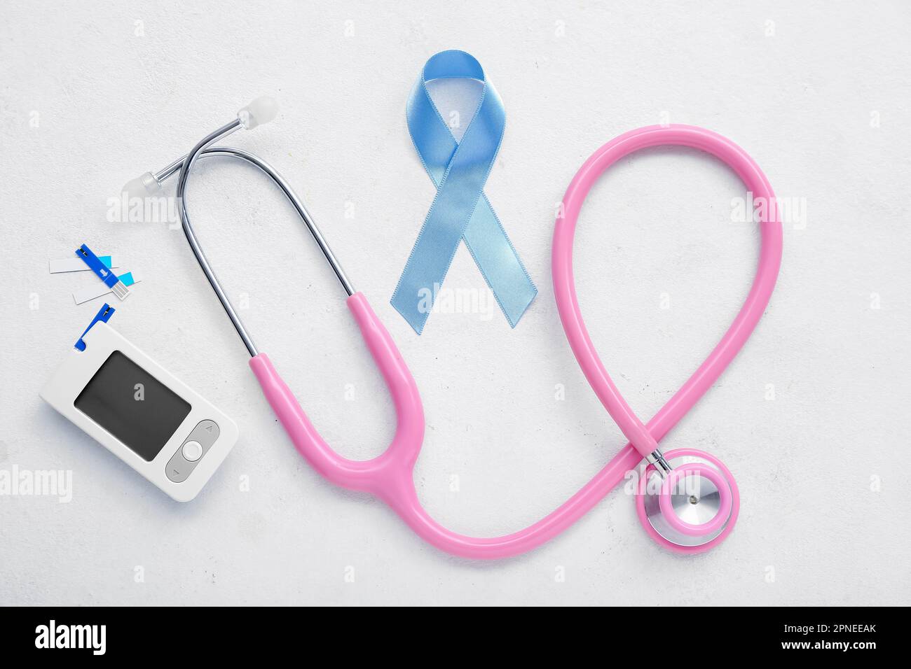 Awareness ribbon with glucometer and stethoscope on white background ...