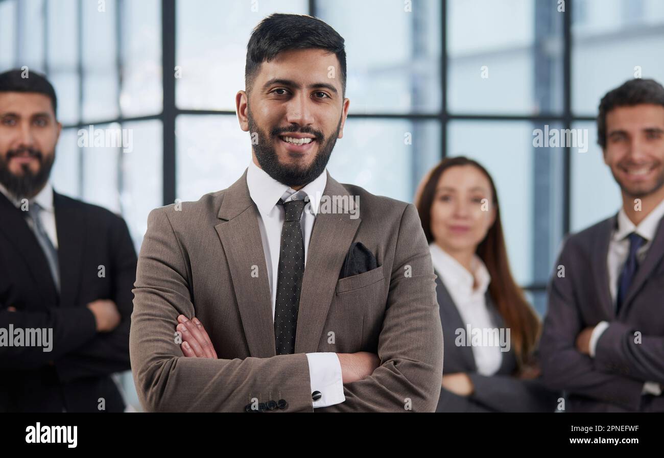 Four business people posing in a modern setting Stock Photo - Alamy