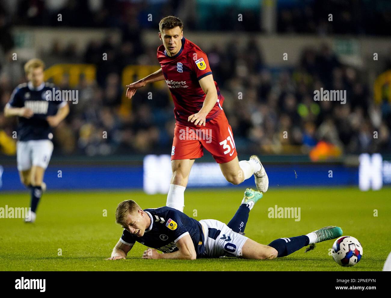 Millwall's Zian Flemming is taken down by Birmingham City's Krystian Bielik during the Sky Bet Championship match at The Den, London. Picture date: Tuesday April 18, 2023. Stock Photo