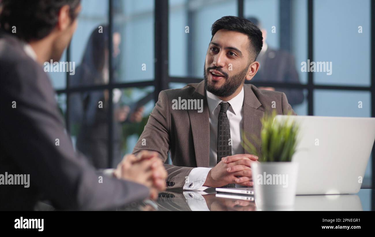 Two medium focused business workers communicate in the office. Stock Photo