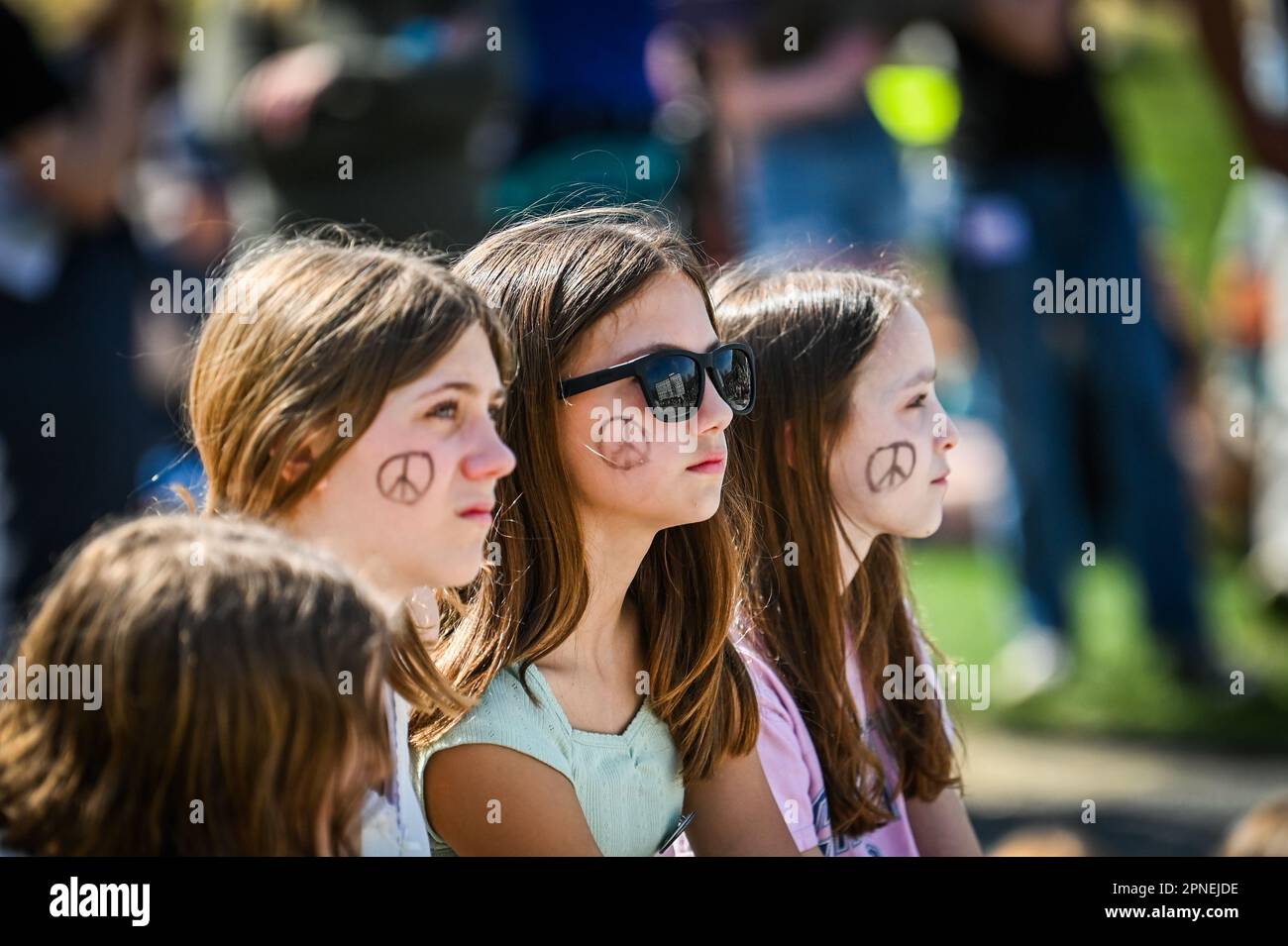 Young people at Youth Lobby’s 2023 Rally for the Planet at the Vermont State House, Montpelier, VT, USA, have peace symbols on their faces. Stock Photo