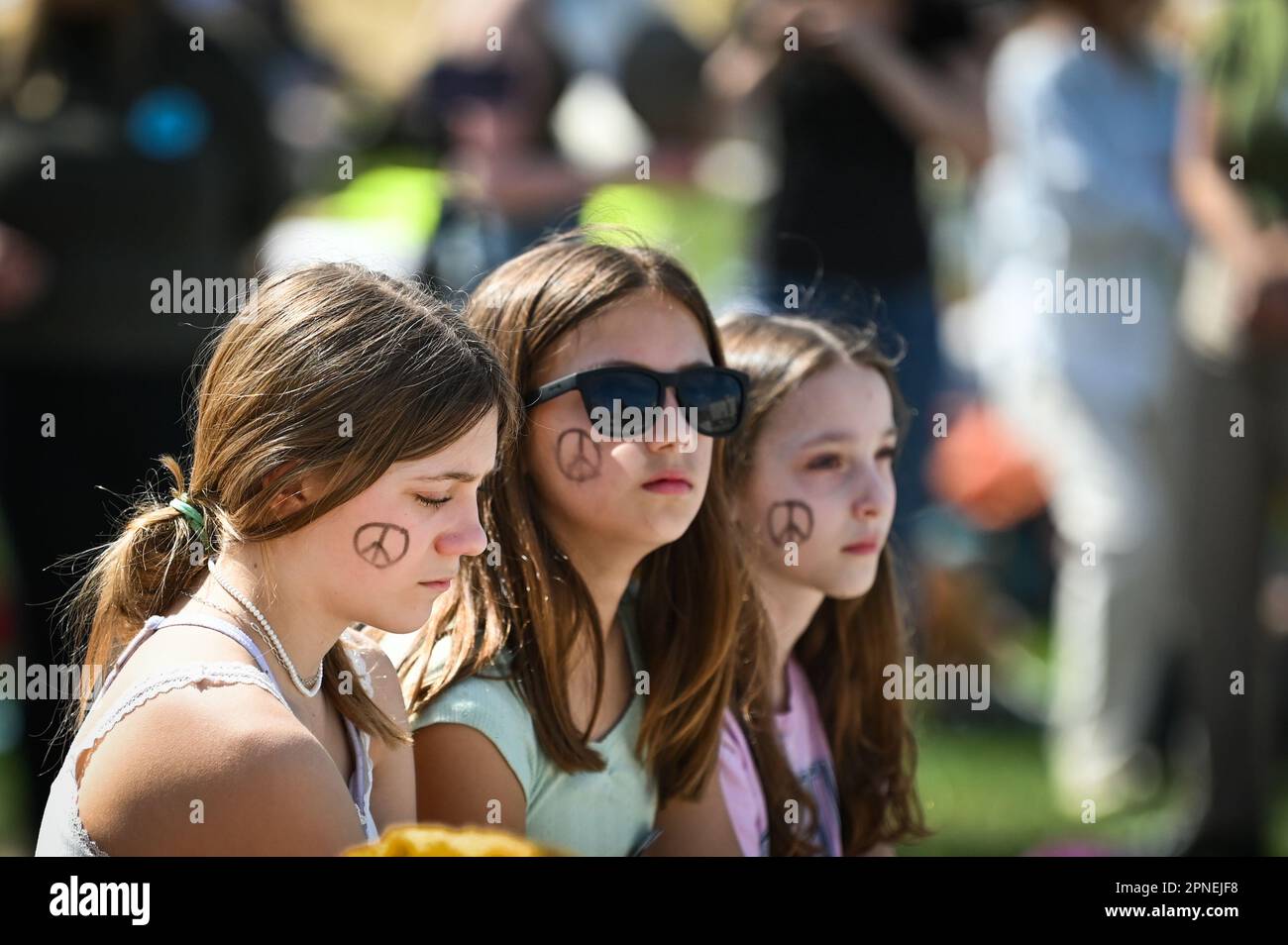 Young people at Youth Lobby’s 2023 Rally for the Planet at the Vermont State House, Montpelier, VT, USA, have peace symbols on their faces. Stock Photo