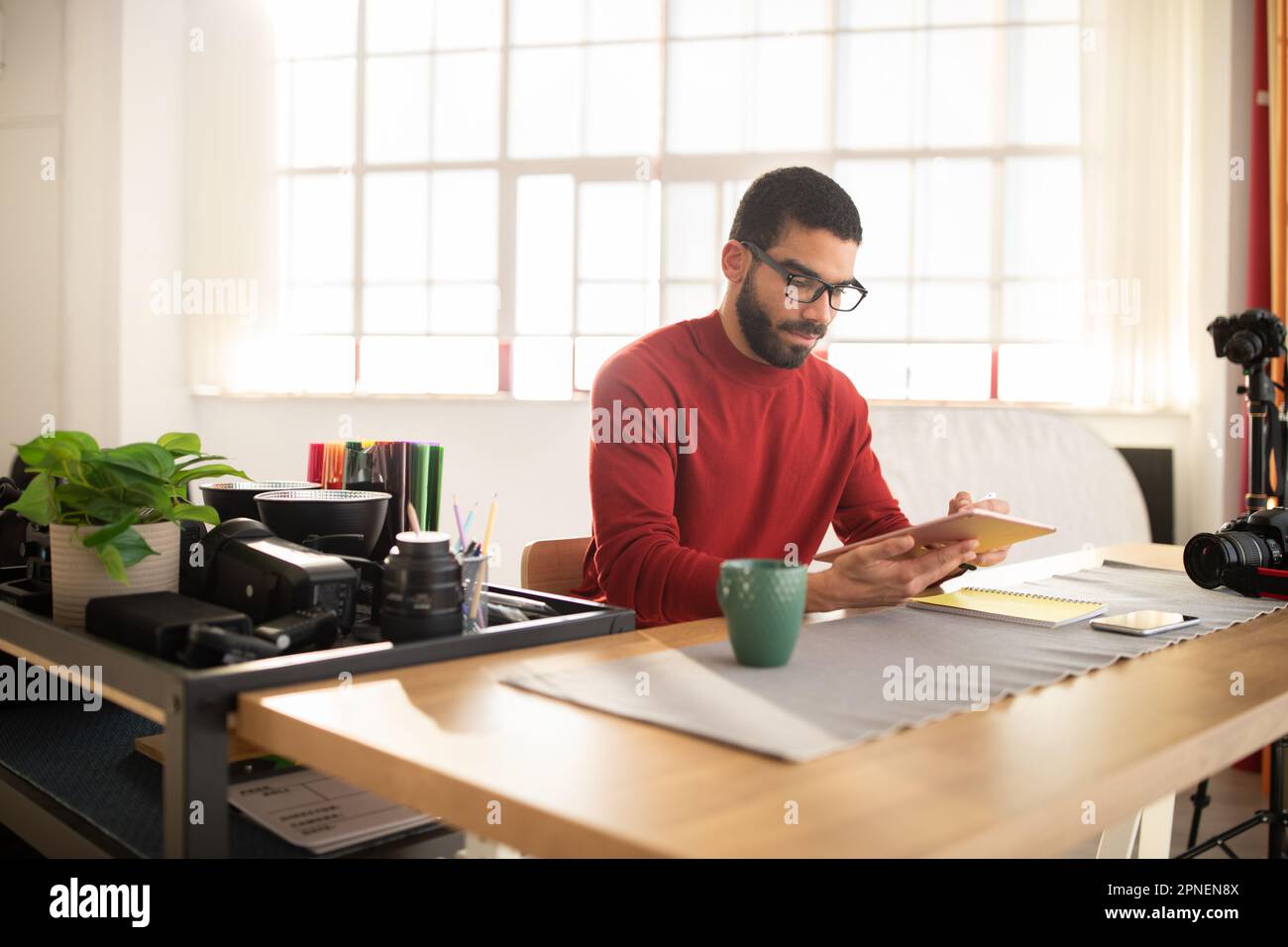 Creative man photographer working at spacious modern studio Stock Photo