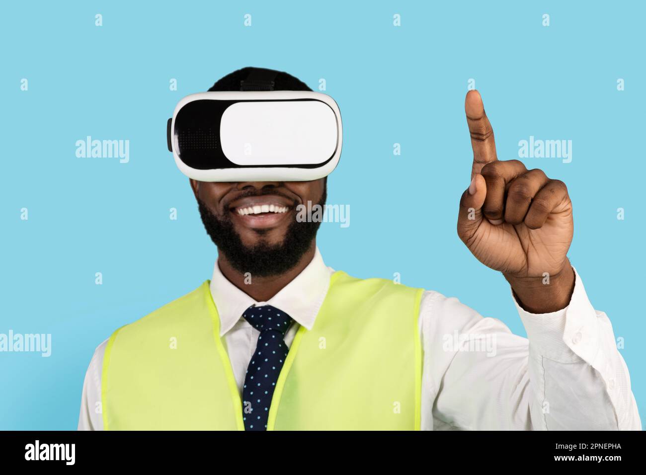 Black Builder Man Using VR Glasses And Touching Air With Finger Stock Photo