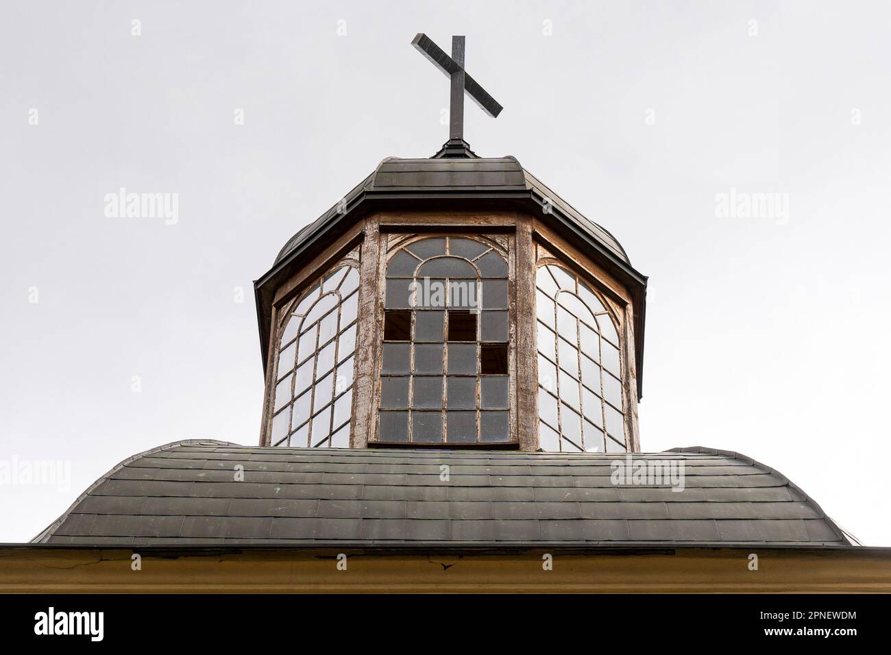 Old church tower with broken windows and with a cross on top Stock Photo