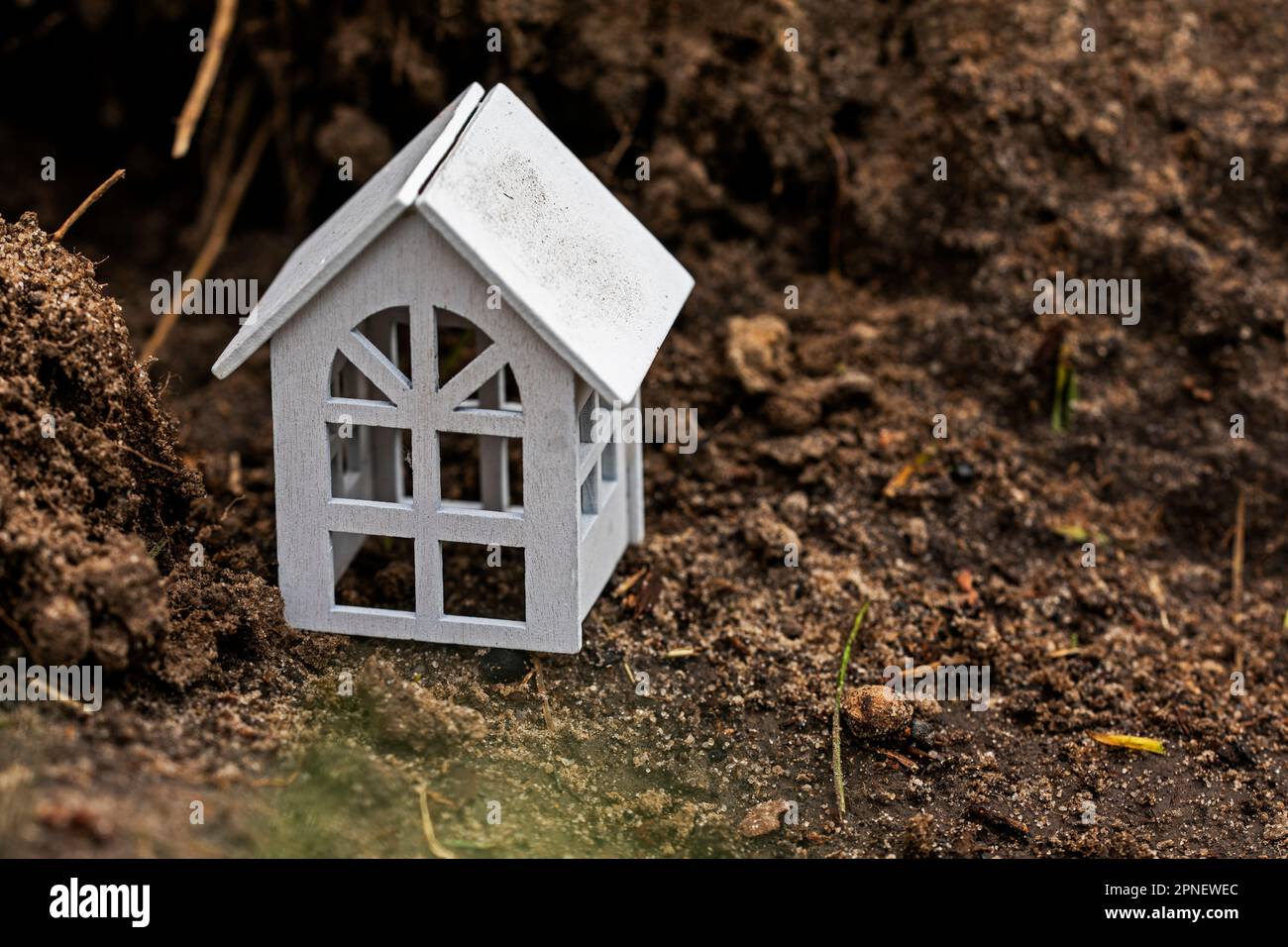 small white house on the background of cracked earth. Ecological catastrophy. Stock Photo