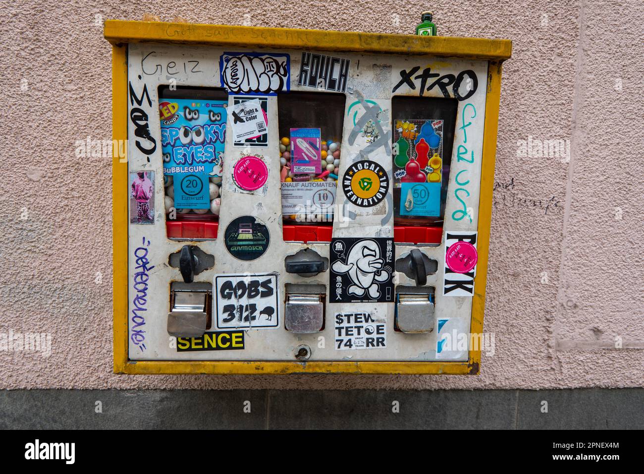 Antiquated wall bubblegum sweet and novelty dispenser near Checkpoint Charlie the best-known Berlin Wall crossing point between East Berlin and West B Stock Photo