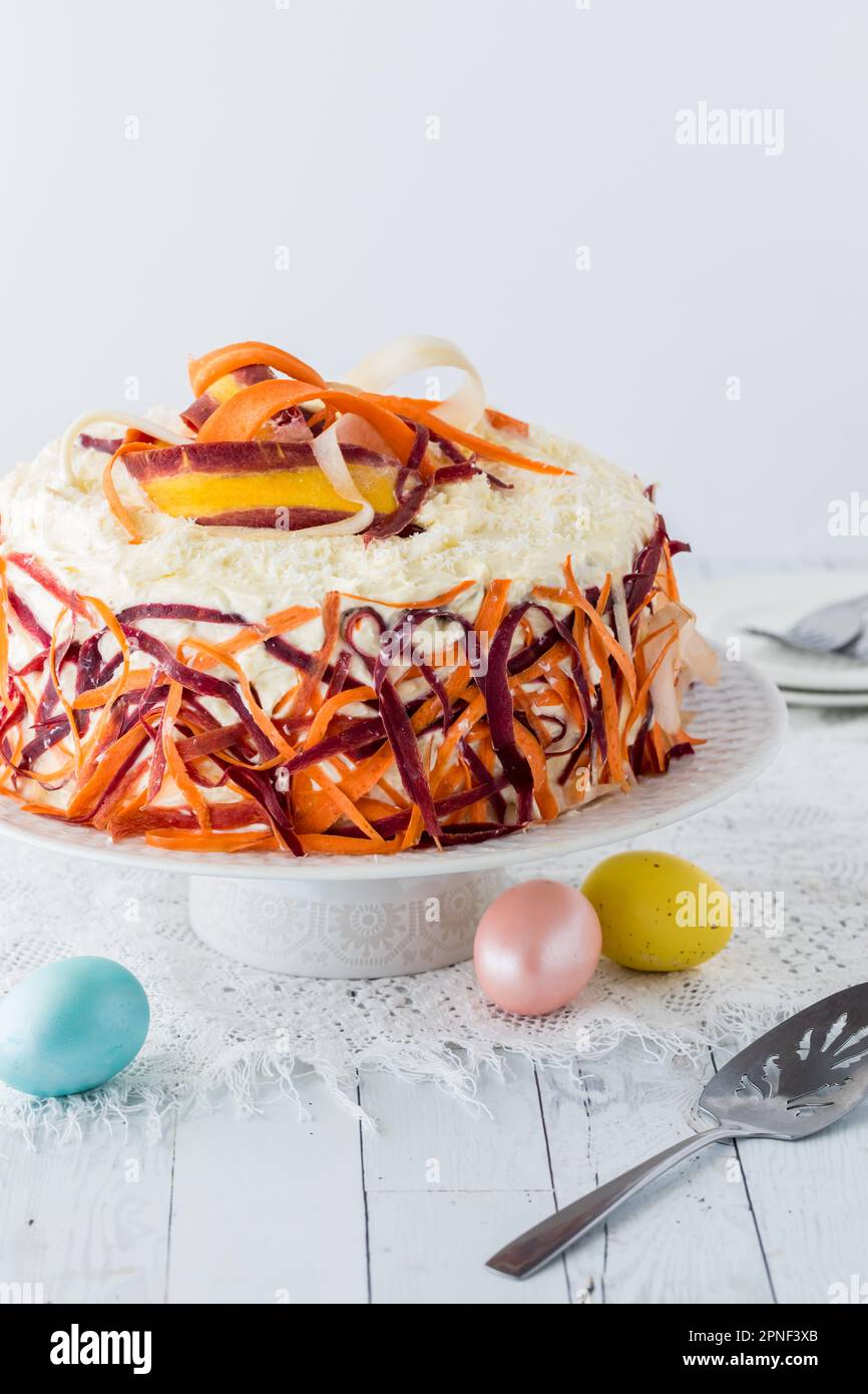 Triple layer buttercream frosted carrot cake decorated with carrot
