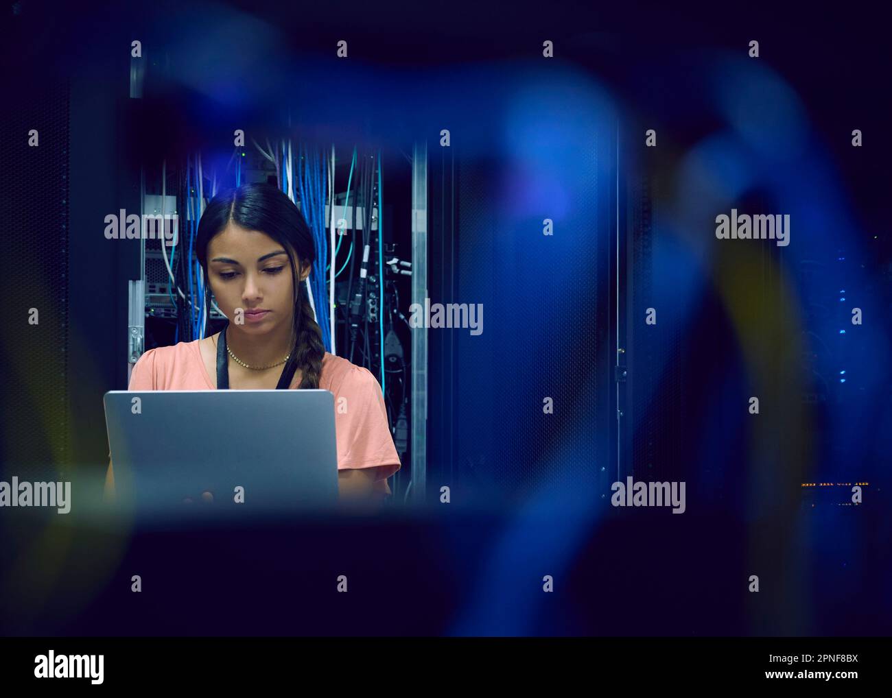 Female technician using laptop in server room Stock Photo