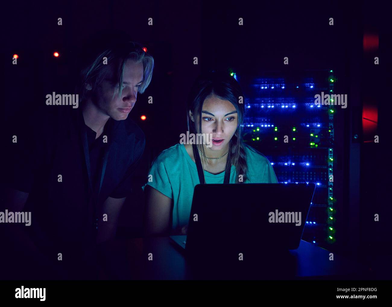 Technicians using laptop in server room Stock Photo