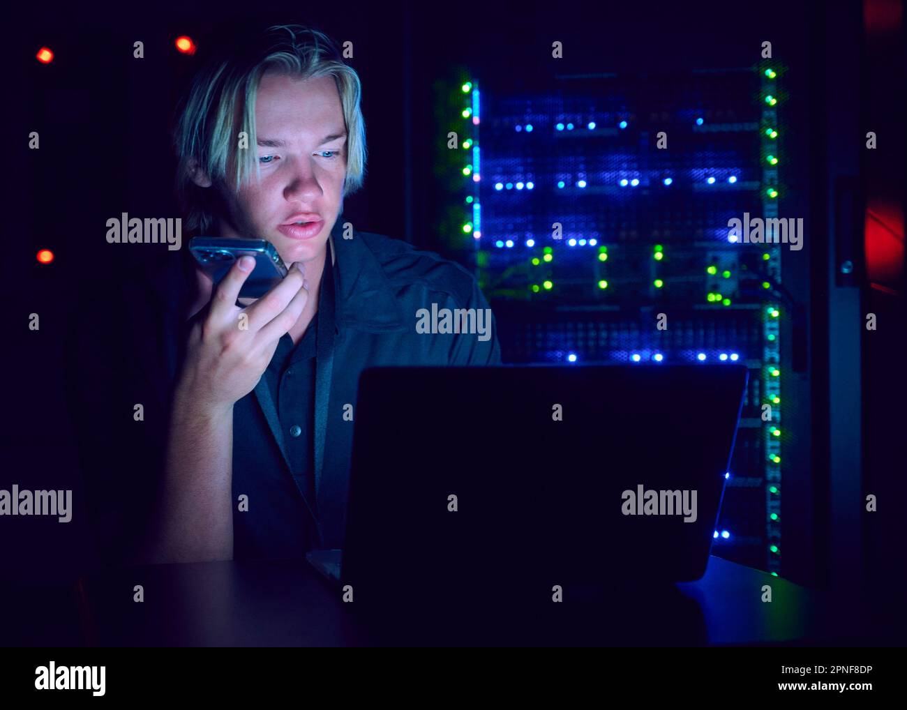 Technician using laptop and smart phone in server room Stock Photo Alamy