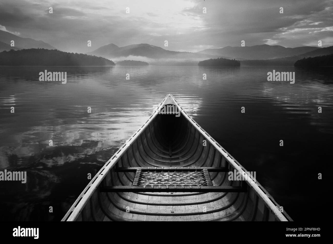 United States, New York, St. Armand, Canoe in morning mist after rain on Lake Placid, Adirondacks State Park, black and white Stock Photo