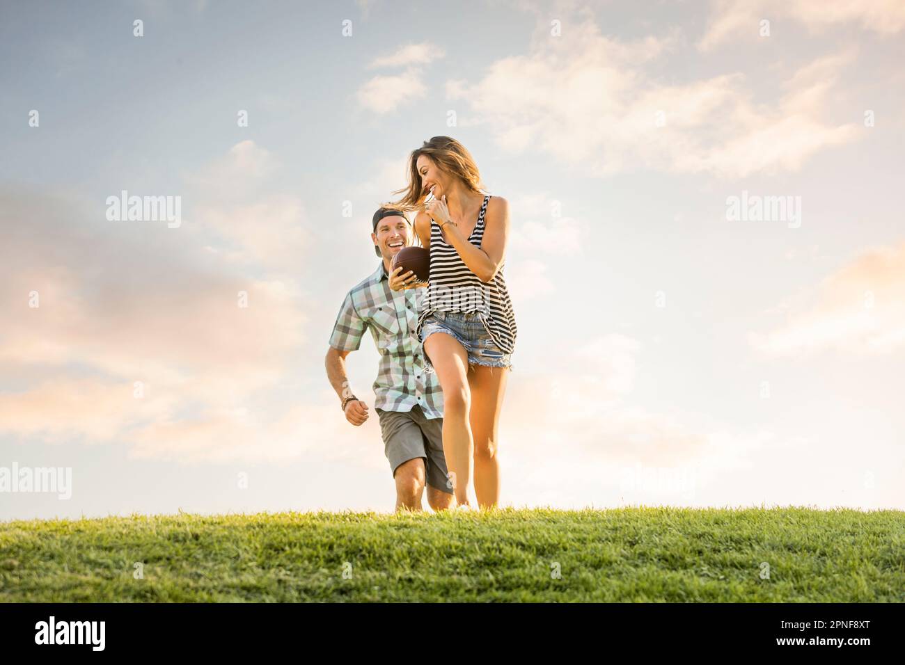 Man running after woman in park Stock Photo