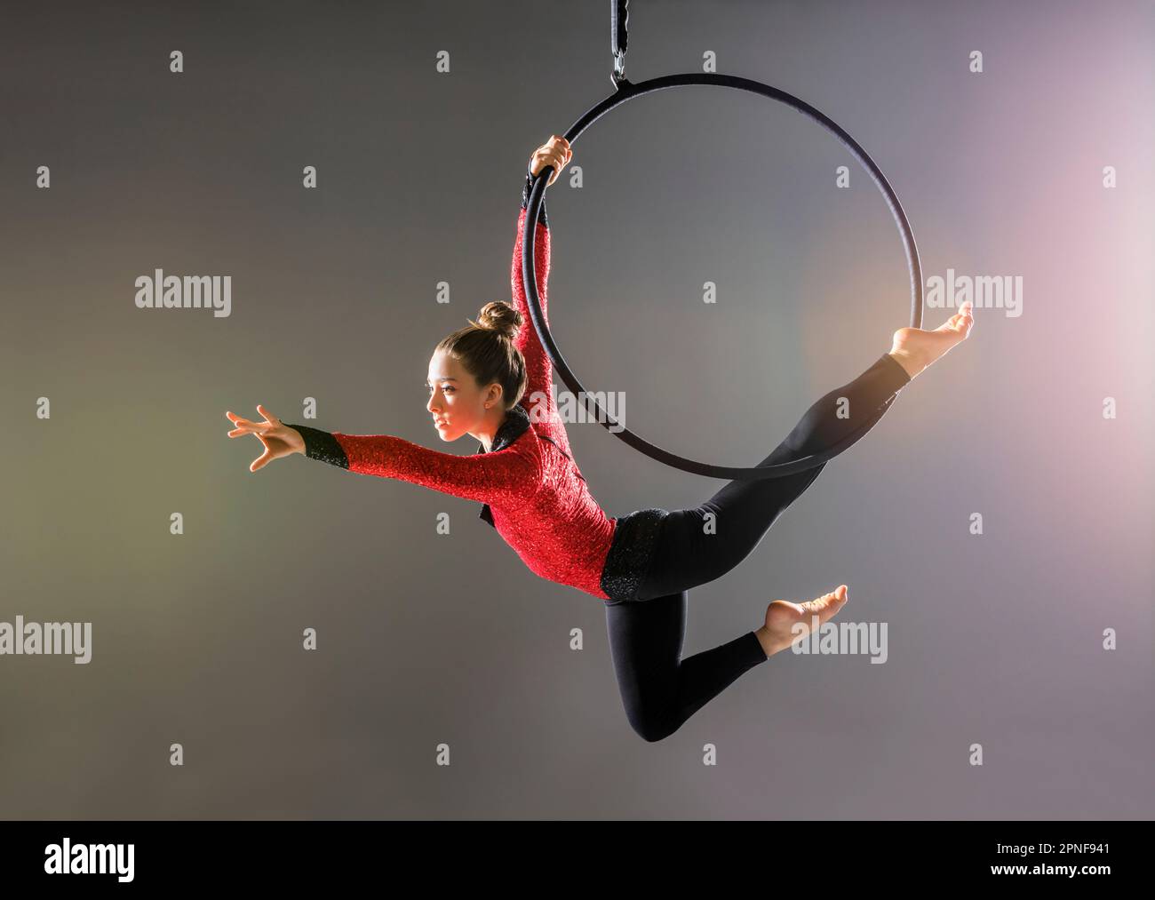 Teenage aerialist (14-15) practicing on gymnastics hoop Stock Photo