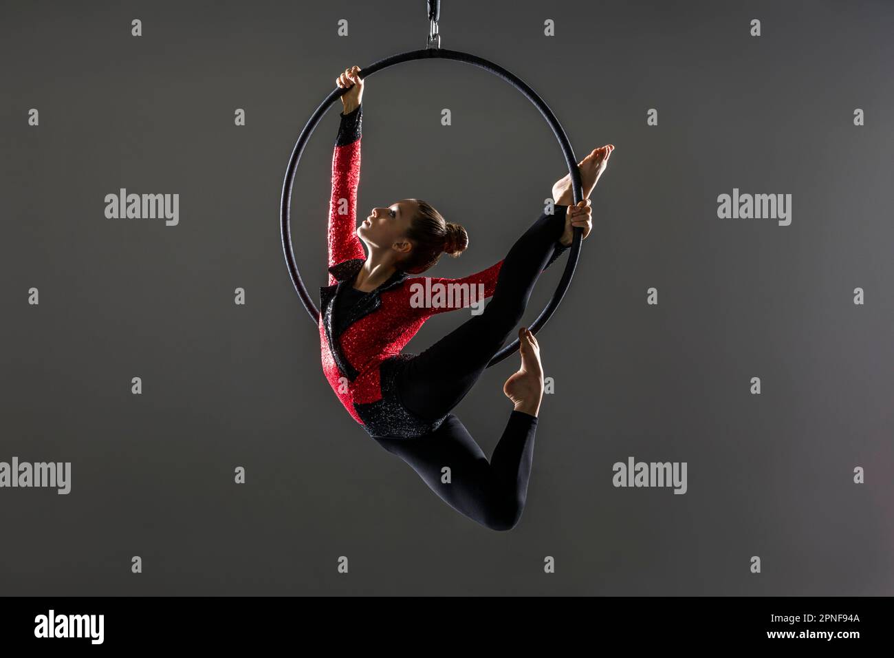 Teenage aerialist (14-15) practising on gymnastic hoop Stock Photo
