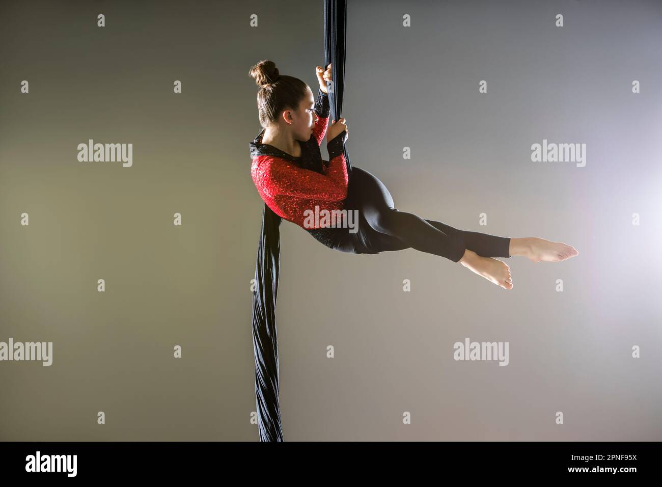 Teenage girl (14-15) performing on aerial silk Stock Photo