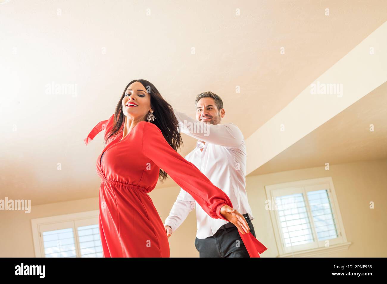 Cheerful couple dancing in apartment Stock Photo