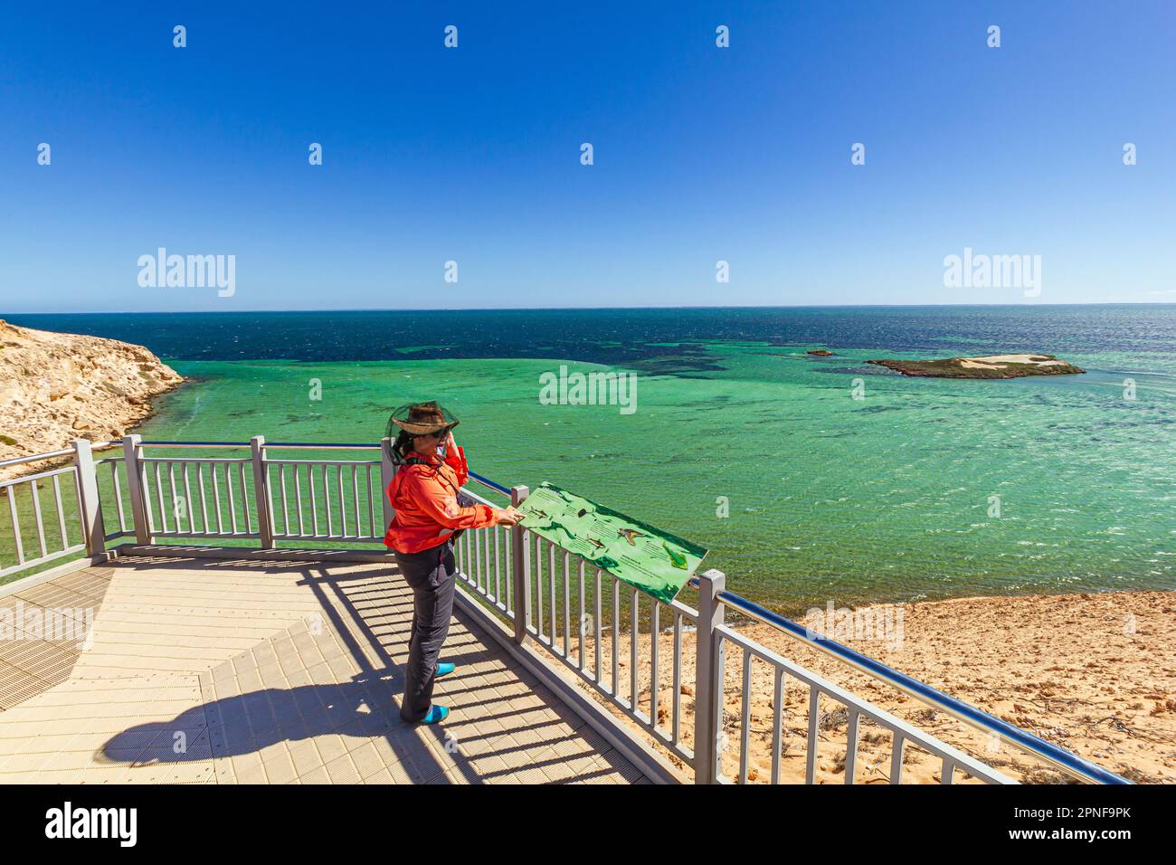 A woman enjoying the the view of seascape of Denham Sound from the Eagle Bluff viewing platform and boardwalk boardwalk at Shark Bay, Australia. Stock Photo