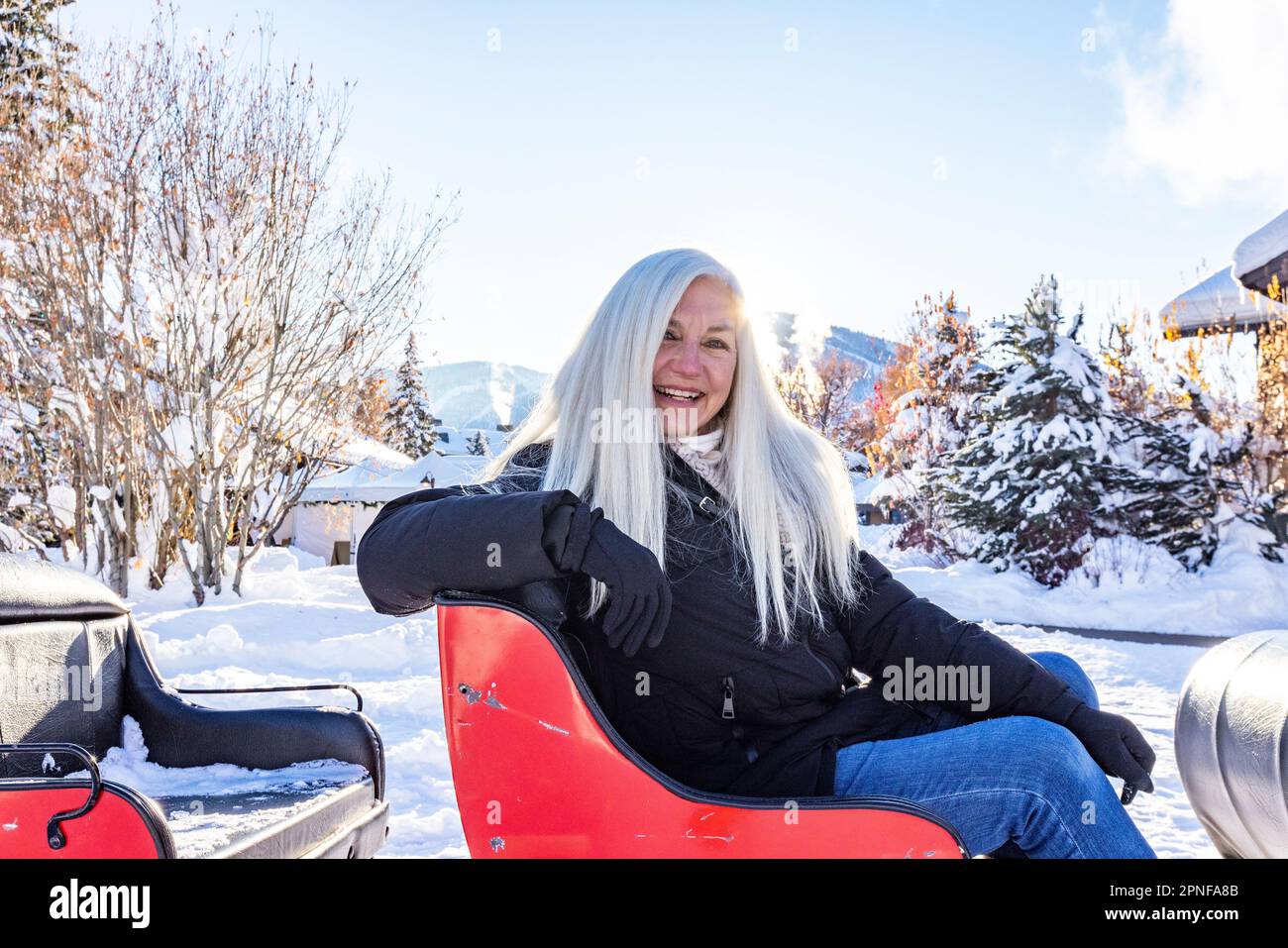 United States, Idaho, Sun Valley, Portrait of senior woman sitting in snowy sleigh Stock Photo