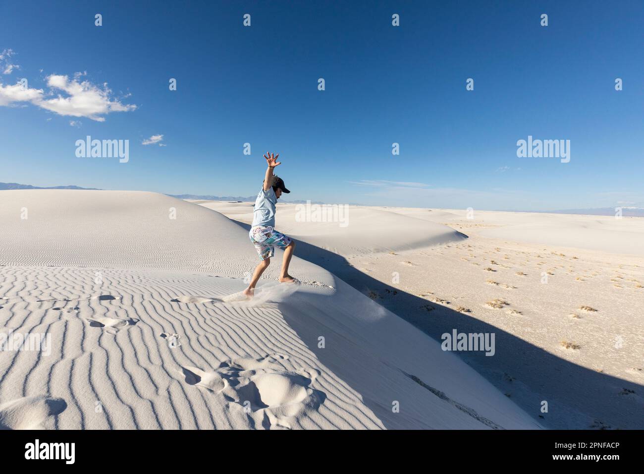 United States, New Mexico, White Sands National Park, Boy (10-11) leaping on sand dunes Stock Photo