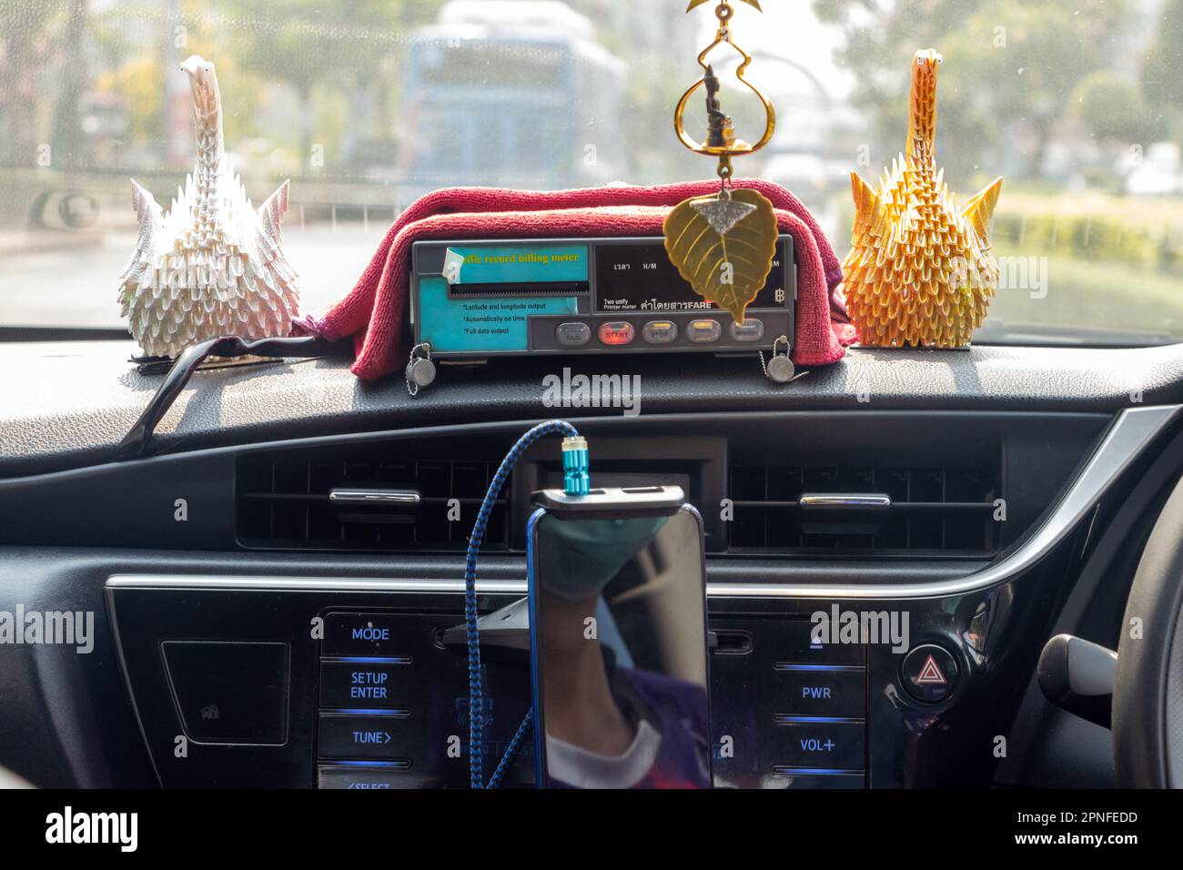 The dashboard of taxi with the digital taxi meters while moving car on a city street, Bangkok, Thailand Stock Photo