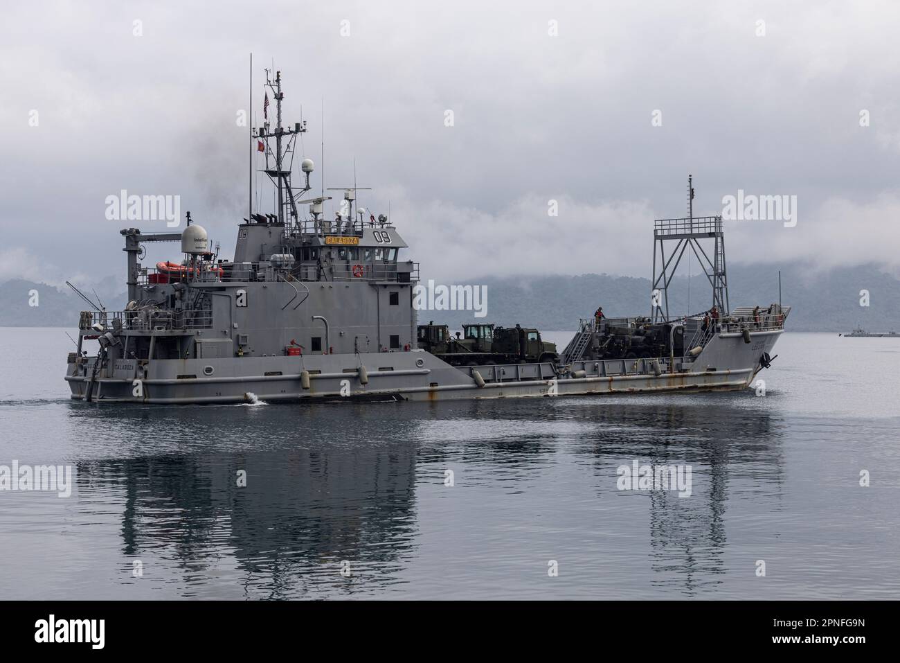 U.S. Army landing craft, utility USAV Calaboza (LCU-2009) departs with the final onload for combined joint logistics over-the-shore operations in preparation for Balikatan 23 at Camp Agnew, Casiguran, Philippines, April 13, 2023. A combined force of logisticians and support personnel from the Armed Forces of the Philippines and the U.S. military are planning and executing a combined joint logistics over-the-shore event during Balikatan 2023, the annual bilateral exercise between the two Allies. This complex process increases their mutual proficiency in supplying forces ashore in an expeditiona Stock Photo