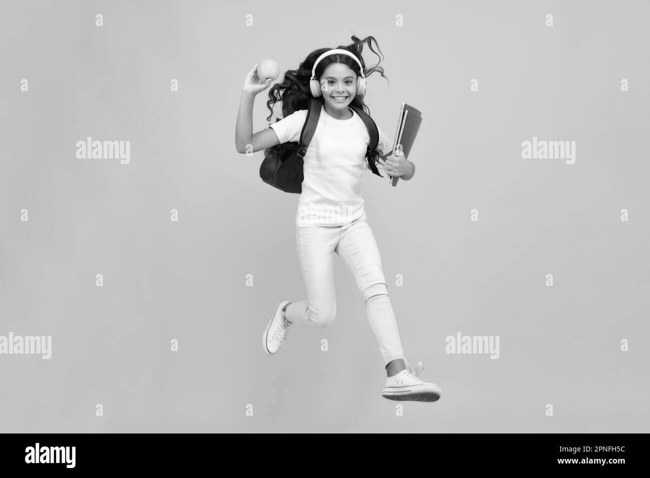 Back to school. Teenager school girl with backpack and headphones hold ...