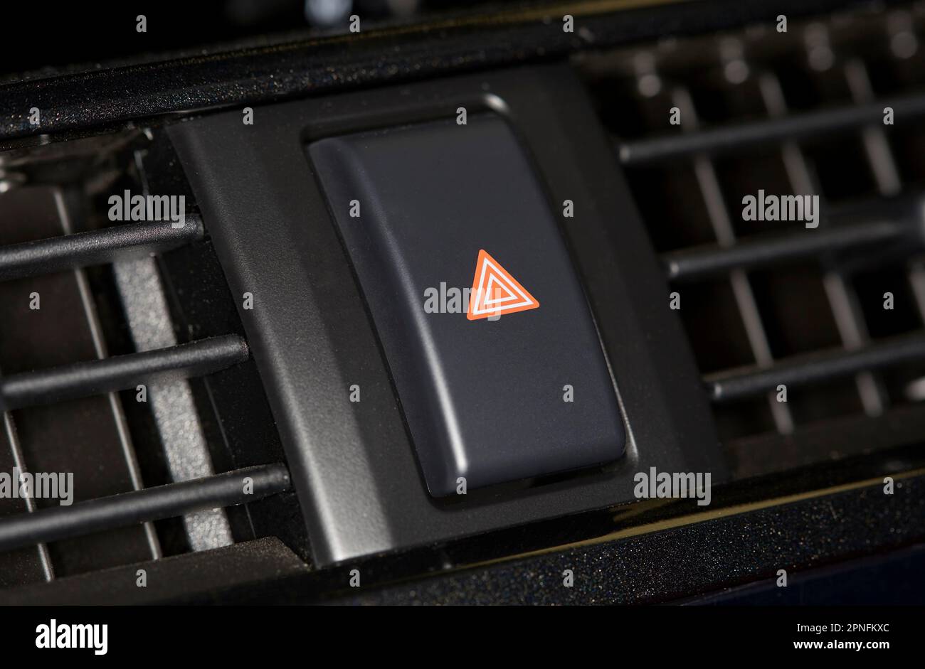 Close up of an interior car dashboard hazard button and vents Stock