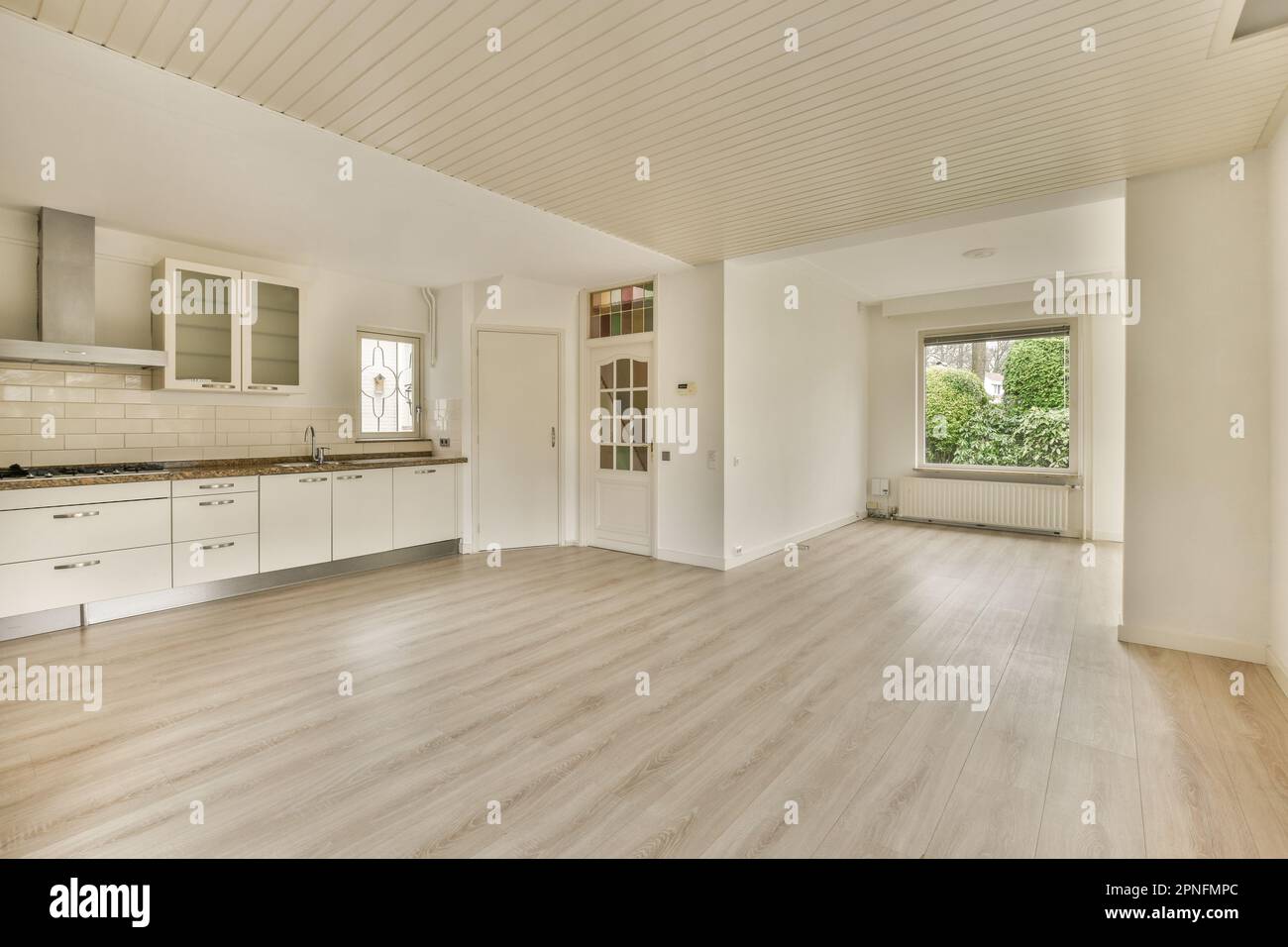 an empty kitchen with wood floors and white appliances on the counter ...