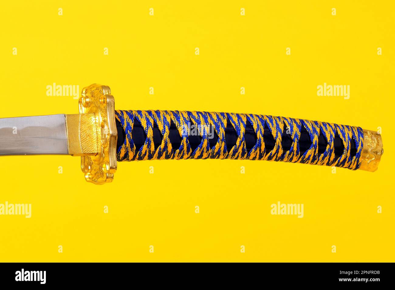 Samurai Sword, blade, guard, and hilt isolated over yellow Stock Photo