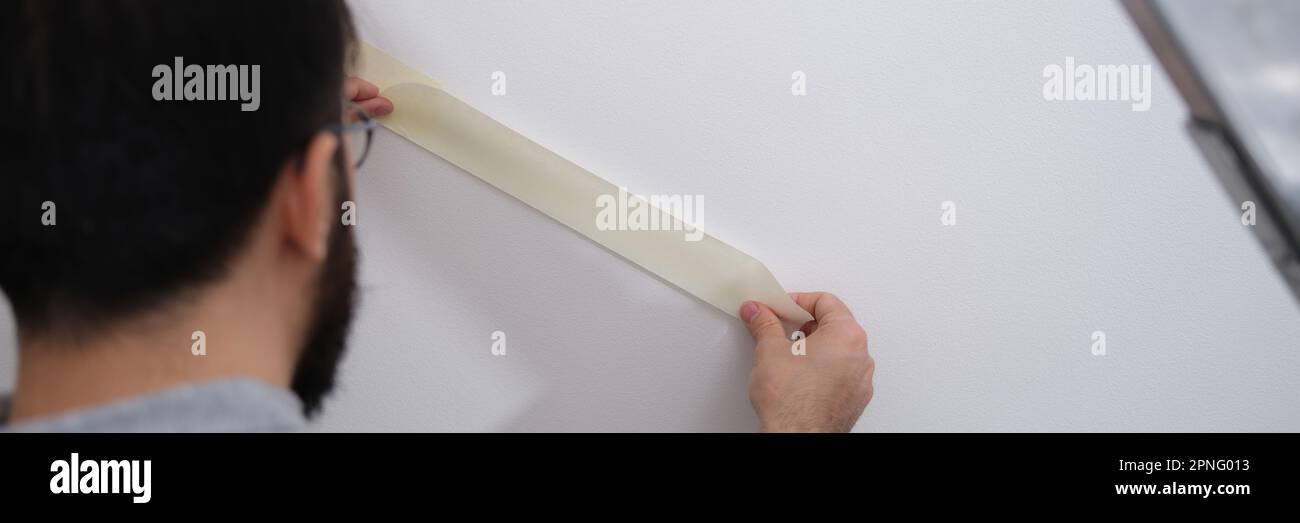 Home repair master using masking tape before painting Stock Photo Alamy
