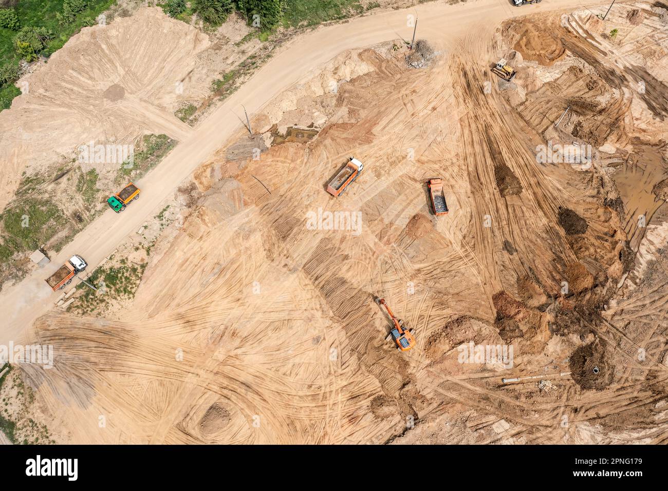 aerial view of large construction site with several earthmovers and dump trucks. Stock Photo