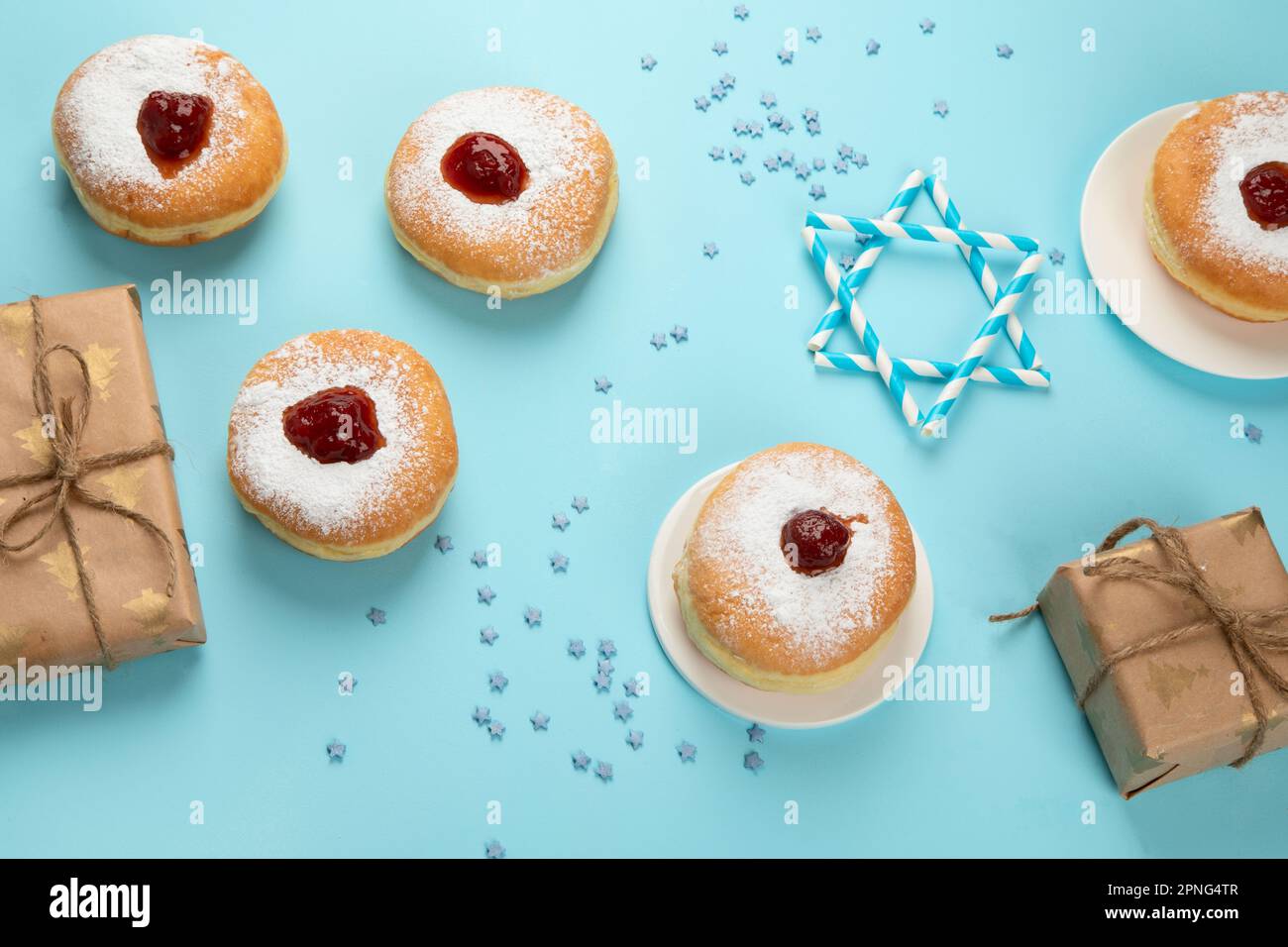 Hanukkah sweet doughnuts sufganiyot (traditional donuts) with fruit jelly jam and white candles