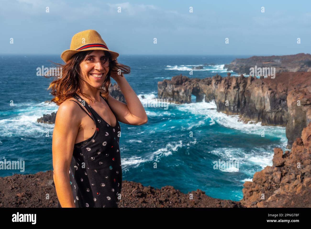 El Hierro Island. Canary Islands, a young tourist woman smiling at the Arco de la Tosca. monument on the coast Stock Photo