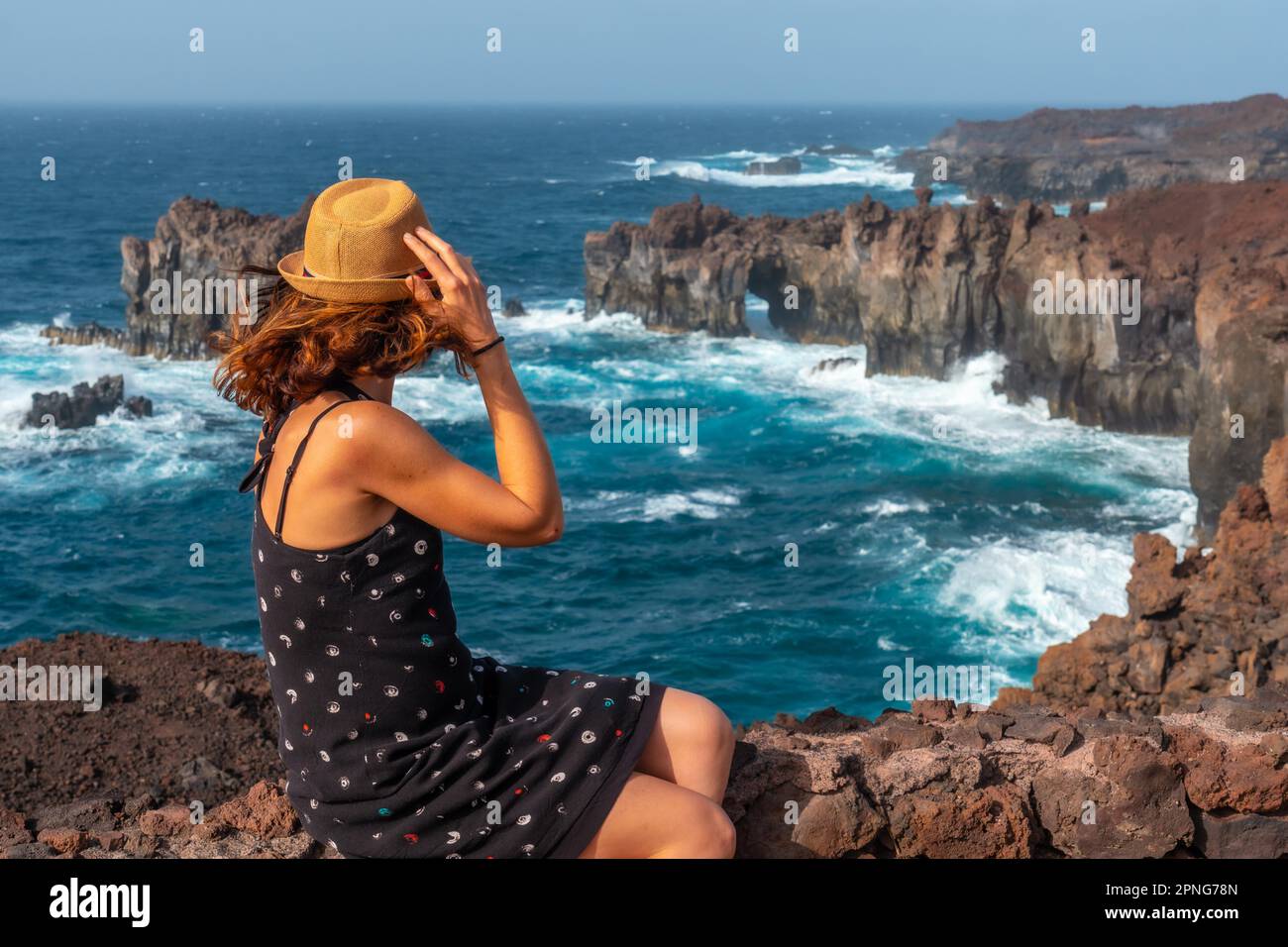 El Hierro Island. Canary Islands, a young tourist in the Arco de la Tosca sitting. monument on the coast Stock Photo