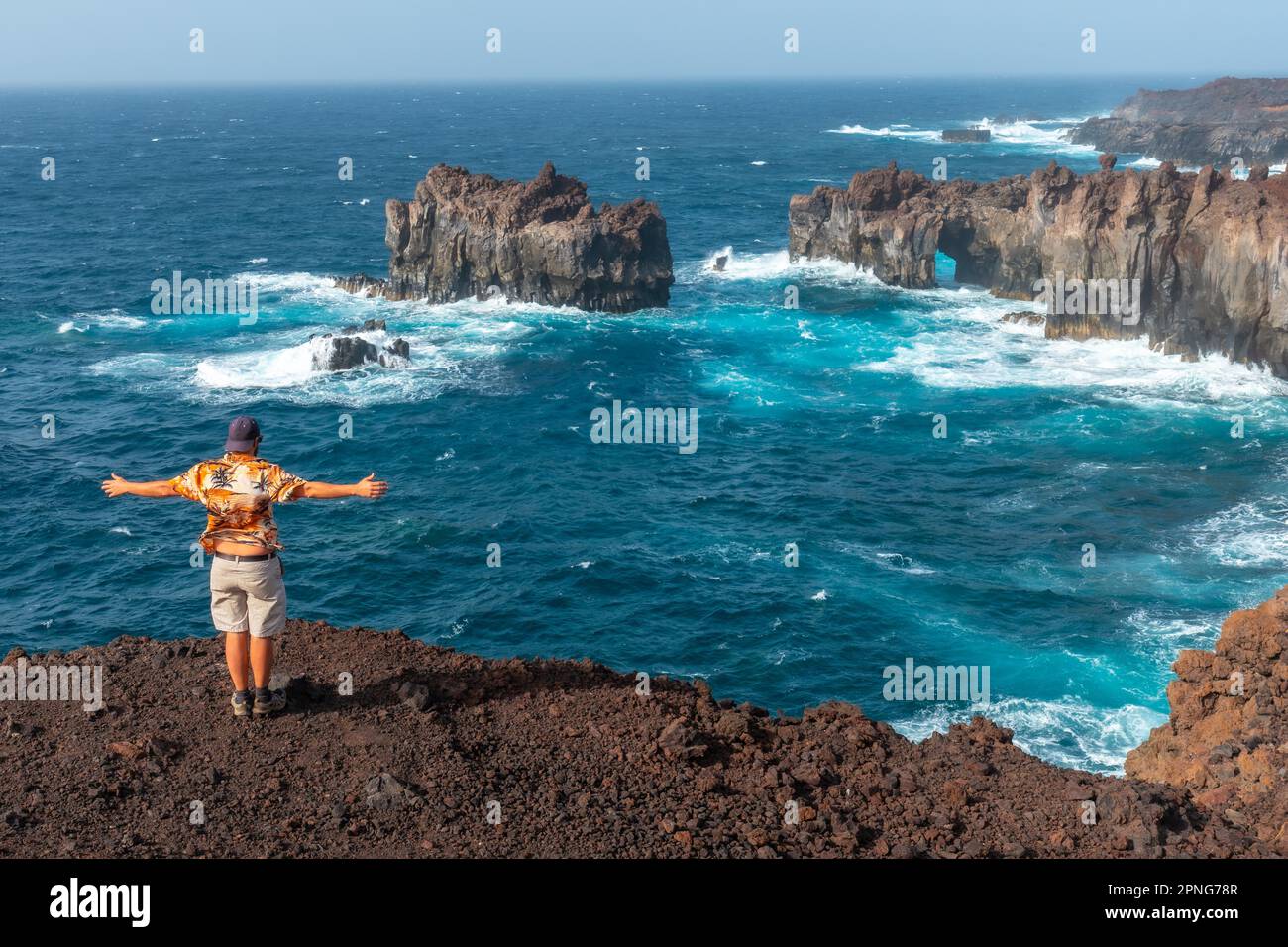 El Hierro Island. Canary Islands, man tourist at the Arco de la Tosca looking at the monument on the coast Stock Photo