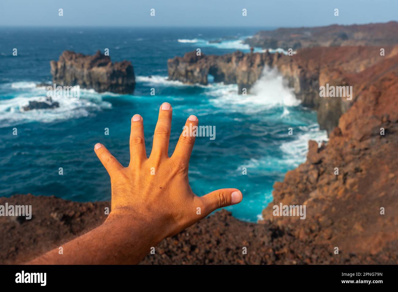El Hierro Island. Canary Islands, hand of a tourist in the Arco de la Tosca enjoying by the sea Stock Photo