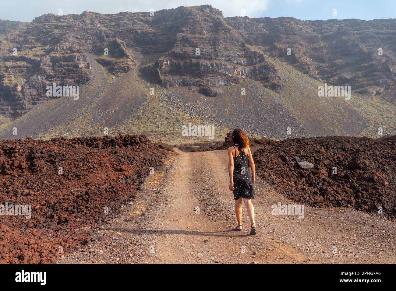 El Hierro Island. Canary Islands, tourist woman in the Arco de la Tosca walking on a volcanic path along the coast Stock Photo