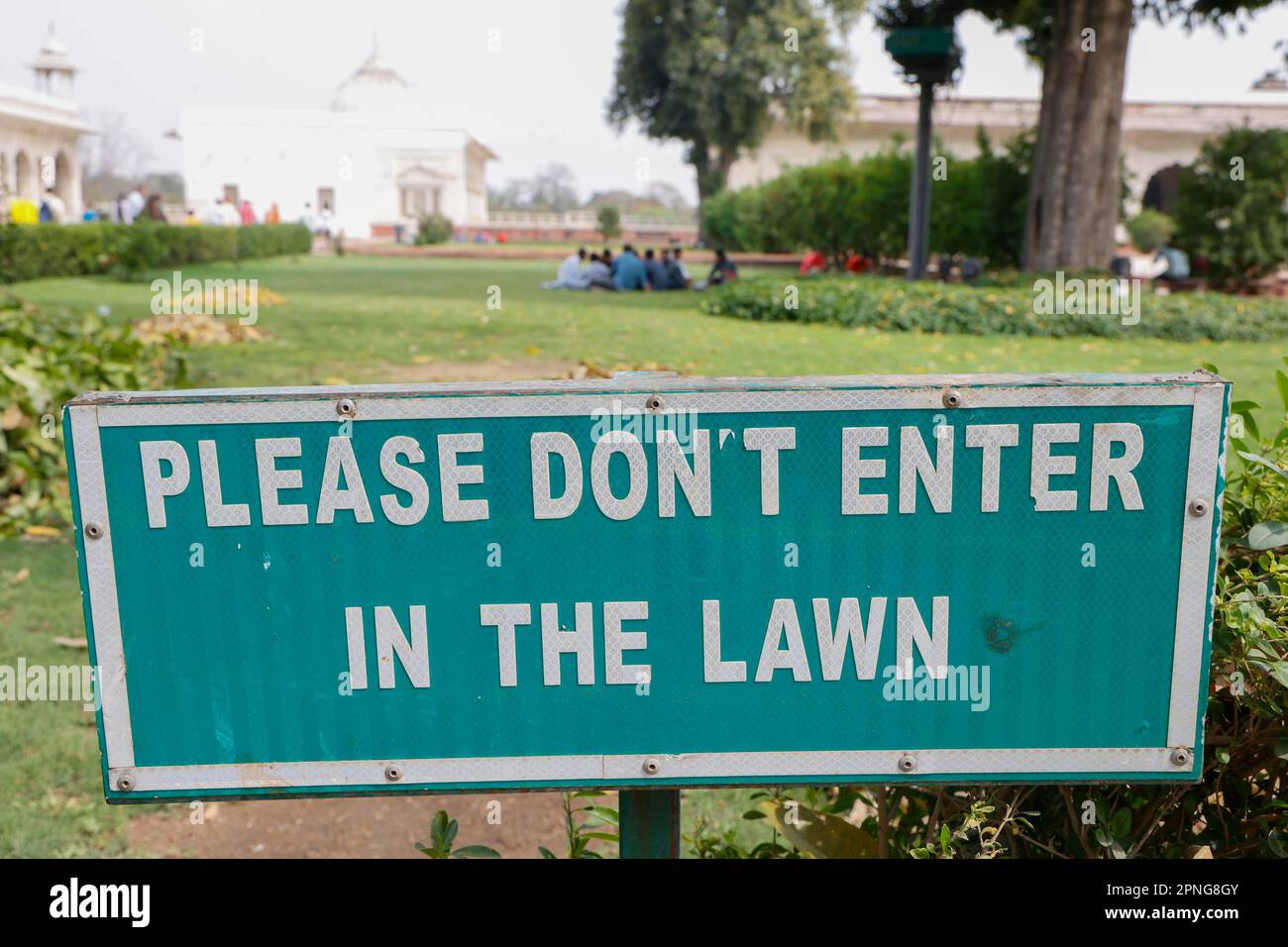 Tourists ignore the sign and picnic on the lawn, Red Fort, Delhi, India Stock Photo