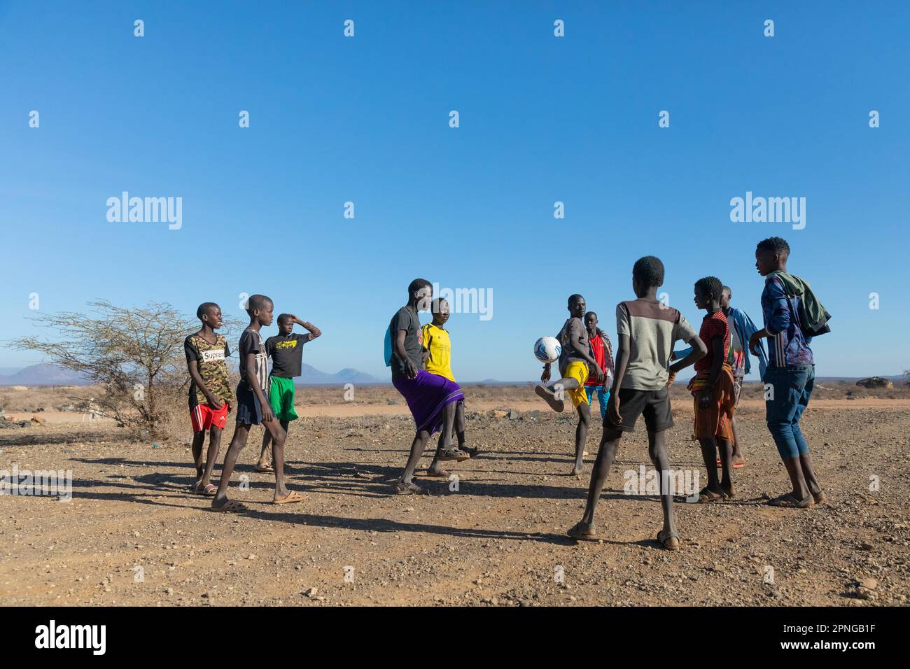 Group of young men playing football, Samburu National Reserve, Kenya Stock Photo