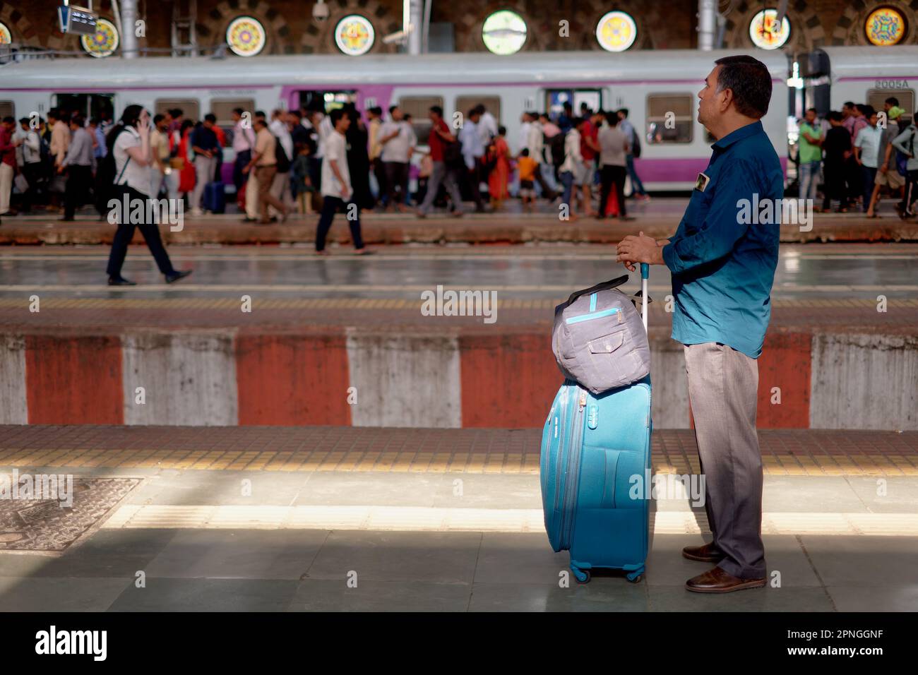 A passenger with luggage waiting for a suburban train at Chhatrapati
