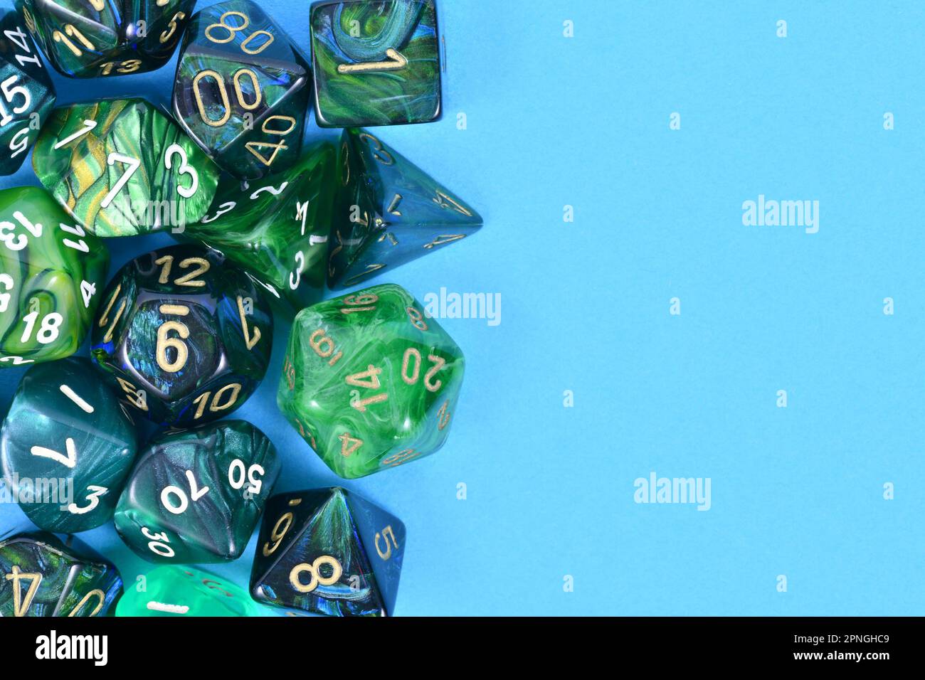 Different blue and green roleplaying RPG dice on side of blue background with blank copy space Stock Photo