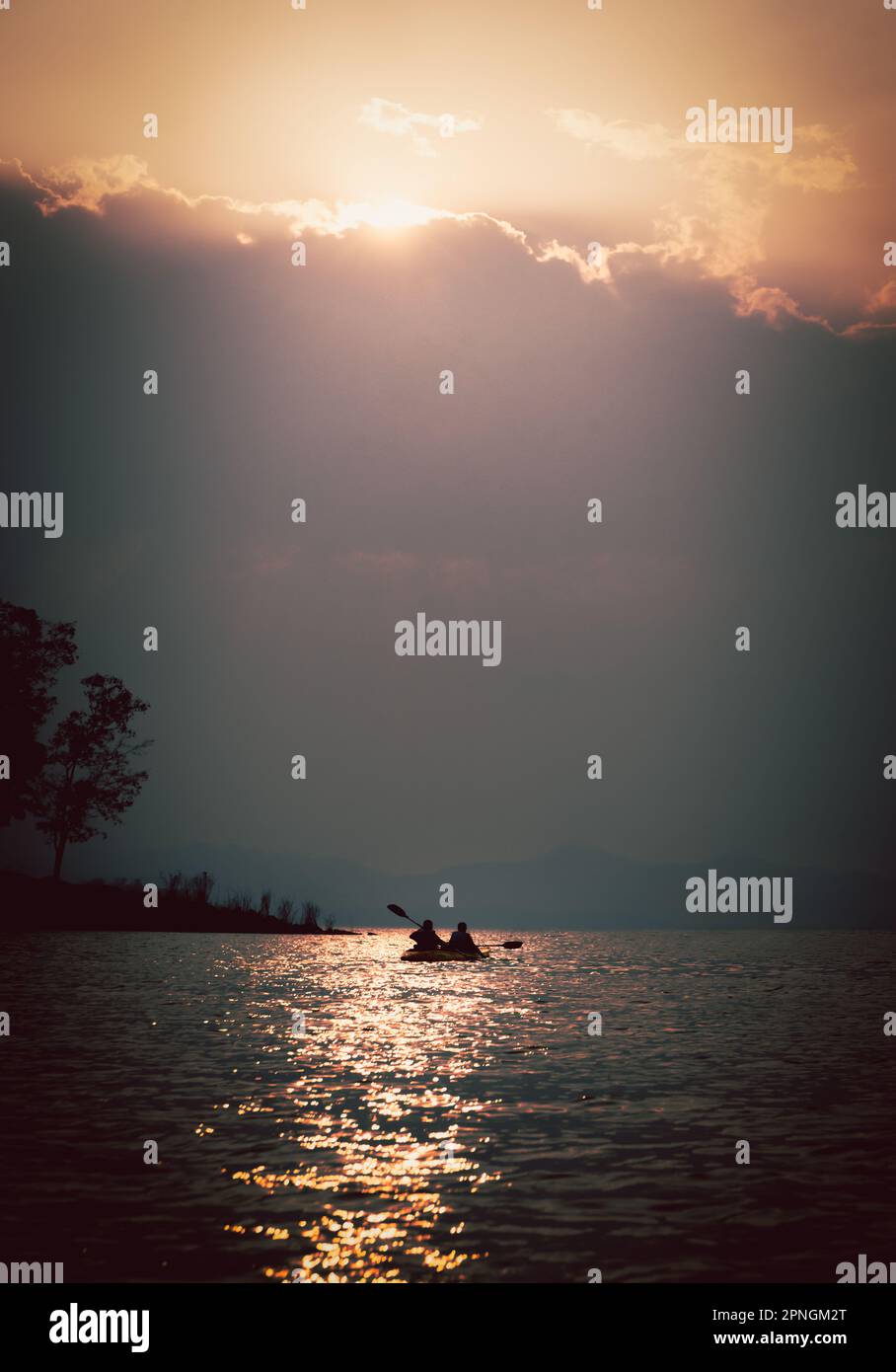 Silhouettes of people in kayak at sunset Stock Photo - Alamy