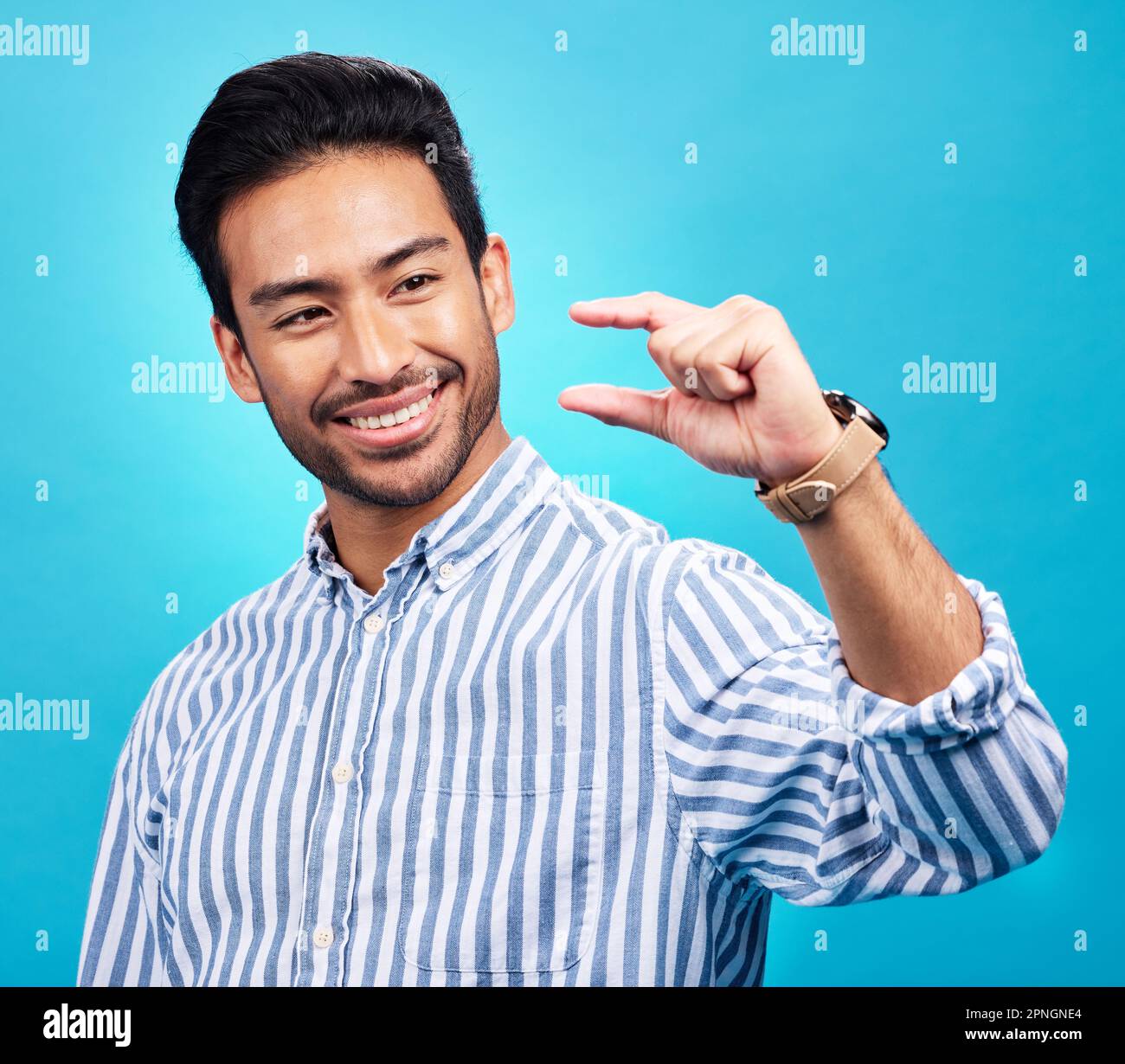 Small, hand and gesture of a man with a smile in studio showing a tiny