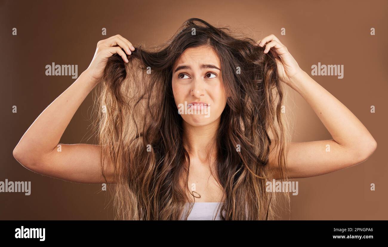 Problem, hair loss and sad woman in studio for beauty, messy and damage against brown background. Haircare, fail and unhappy girl frustrated with weak Stock Photo
