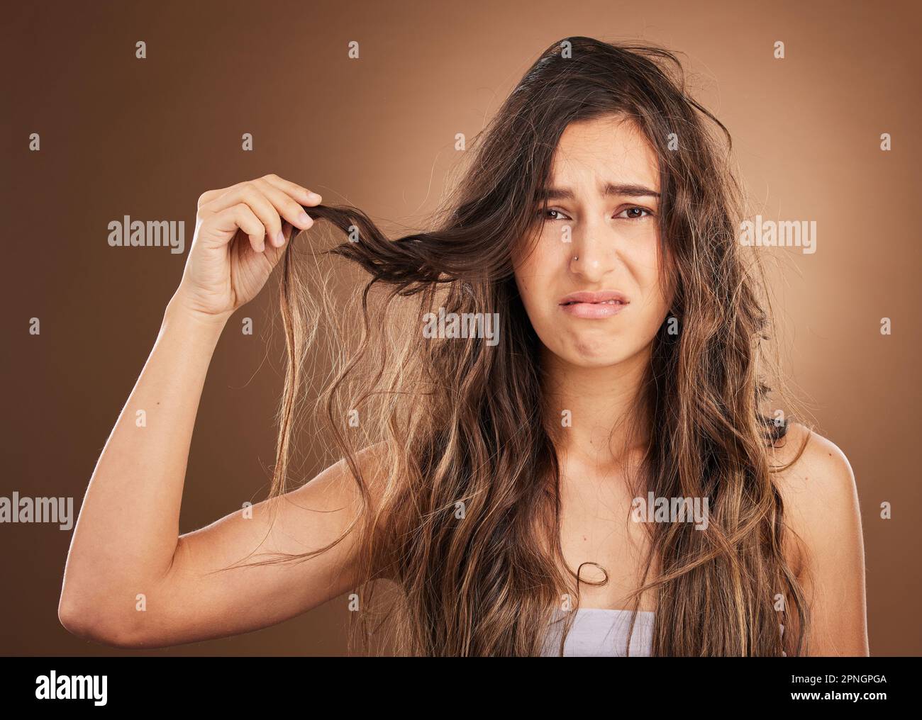 Hair loss, problem and portrait woman in studio for beauty, messy and damage against brown background. Haircare, fail and face of sad girl frustrated Stock Photo
