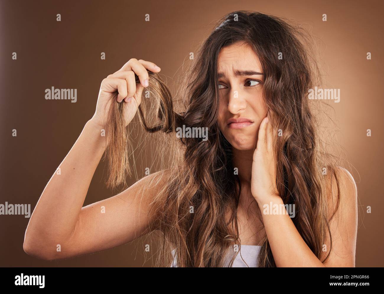Hair loss, crisis and worried woman in studio for beauty, messy and damage against brown background. Haircare, fail and sad girl frustrated with weak Stock Photo