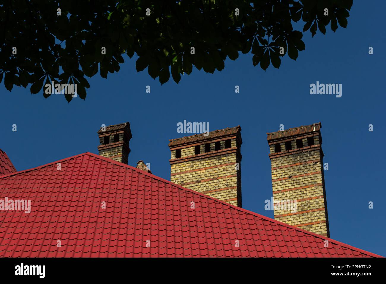 red brick chimney in the top of the village house. A roof made of tiles ...