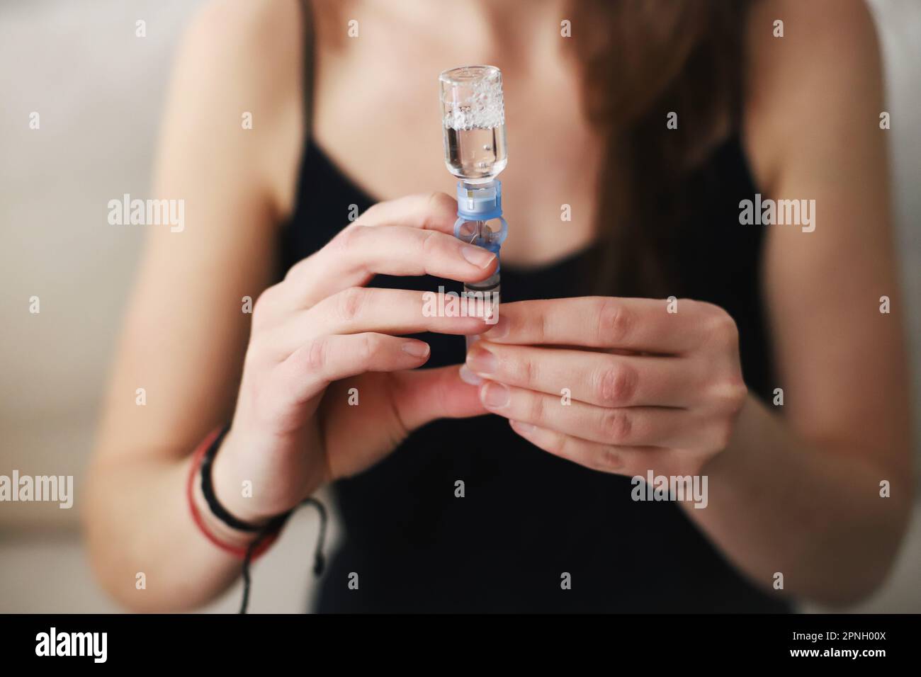 Woman filling up the reservoir of her insulin pump with insulin Stock Photo