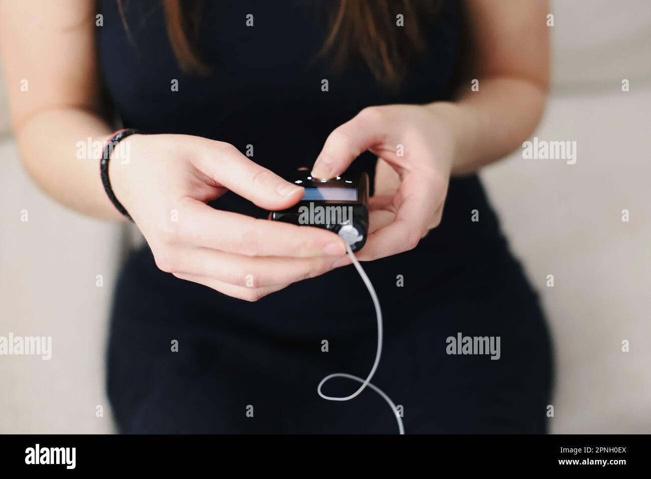 Woman holding her insulin pump in hands Stock Photo